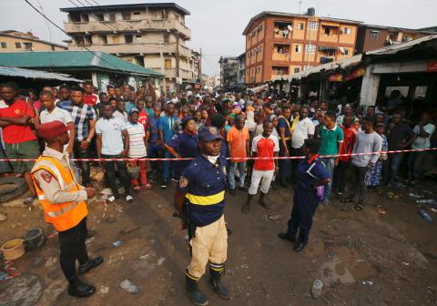 People gather outside a cordoned off area at the site of a collapsed building containing a school in Nigeria's commercial capital of Lagos, Nigeria, March 14, 2019. PHOTO BY REUTERS/Afolabi Sotunde