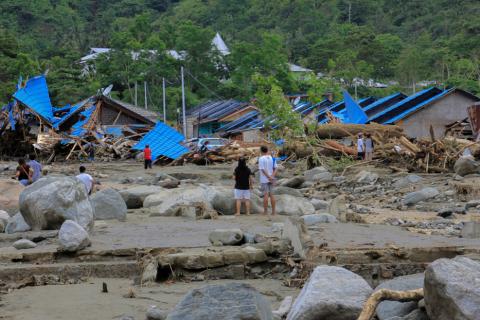 People stand as they look at damaged houses after a flash flood in Sentani, Papua, Indonesia, March 17, 2019. PHOTO BY REUTERS/Antara Foto/Gusti Tanati