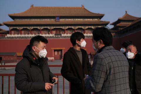 People wearing protective masks stand outside the main entrance of the Forbidden City where a notice is seen saying that the place is closed to visitors for the safety concern following the outbreak of a new coronavirus, in Beijing, China, January 25, 2020. PHOTO BY REUTERS/Carlos Garcia Rawlins