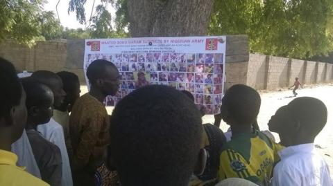 People look at pictures of wanted Boko Haram suspects on a notice posted by the Nigerian military, in Maiduguri, Borno State, Nigeria, November 13, 2015. PHOTO BY REUTERS/Stringer