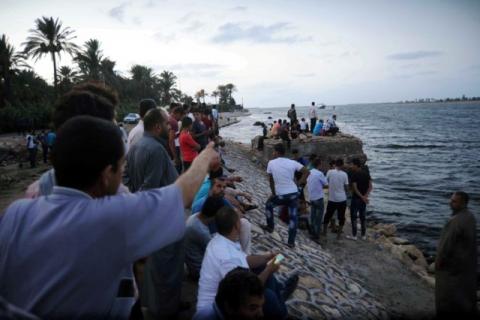 People gather along the shore of the Mediterranean Sea during a search for victims after a migrant boat capsized, in Al-Beheira, Egypt, September 21, 2016. PHOTO BY REUTERS/Stringer