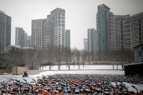 A person wearing a face mask rides an electric scooter near bike-sharing bicycles, as the country is hit by an outbreak of the new coronavirus, in Beijing, China, February 5, 2020. PHOTO BY REUTERS/Carlos Garcia Rawlins