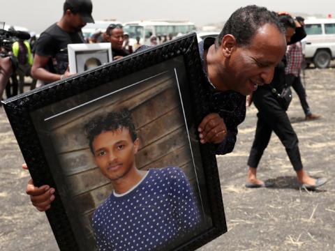 A relative carries a portrait photograph of Ethiopian Airlines pilot Yared Getachew as he mourns at the scene of the Ethiopian Airlines Flight ET 302 plane crash, near the town Bishoftu, near Addis Ababa, Ethiopia March 14, 2019. PHOTO BY REUTERS/Tiksa Negeri