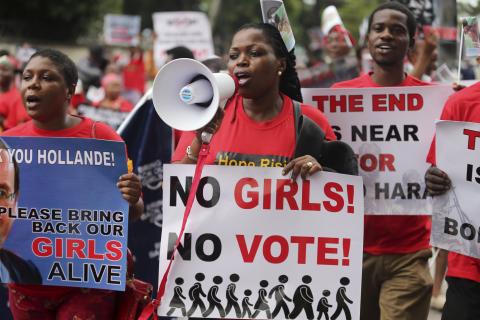 People hold placards calling for the release of secondary school girls abducted in the remote village of Chibok, during a protest along a road in Lagos