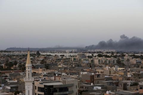 Plumes of black smoke (R) is seen after war planes struck Misrata positions in Tripoli in an attack claimed by renegade general Khalifa Haftar