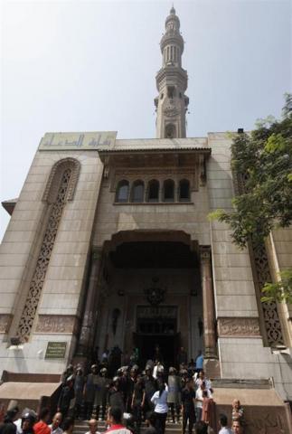 Police officers stand guard in front of al-Fath mosque, where protesters in support of ousted Egyptian President Mohamed Mursi are sitting inside, at Ramses Square in Cairo