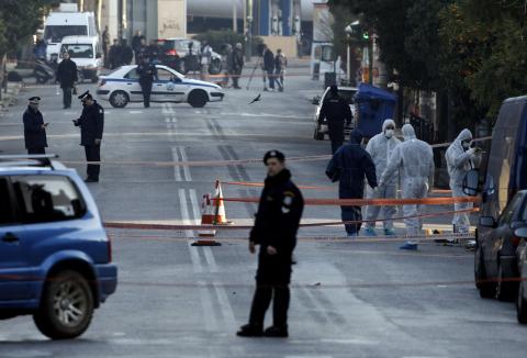 Police experts search for evidence following a gun attack, outside the German ambassador's residence in Chalandri suburb north of Athens