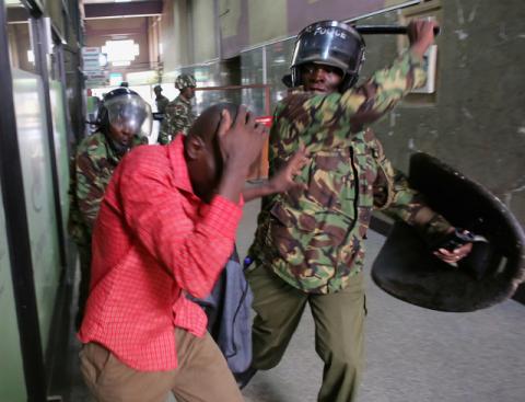 Policemen beat a protester inside a building during clashes in Nairobi, Kenya, May 16, 2016. PHOTO BY REUTERS/Goran Tomasevic