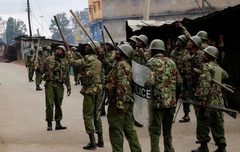 Anti riot policemen look up at residents shouting down at them in Mathare, in Nairobi, Kenya, August 9, 2017. PHOTO BY REUTERS/Thomas Mukoya