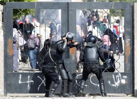 Riot police attempt to break open the entrance of the al-Azhar University Campus during clashes with female university students, who are supporters of the Muslim Brotherhood and ousted Egyptian President Mohamed Mursi, in Cairo's Nasr City district