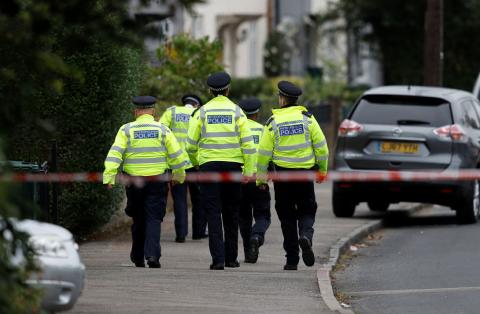 Police officers walk behind cordon tape set up around a property being searched after a man was arrested in connection with an explosion on a London Underground train, in Sunbury-on-Thames, Britain, September 17, 2017. PHOTO BY REUTERS/Peter Nicholls