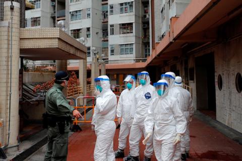 Police in protective gear wait to evacuate residents from a public housing building, following the outbreak of the novel coronavirus, in Hong Kong, China, February 11, 2020. PHOTO BY REUTERS/Tyrone Siu