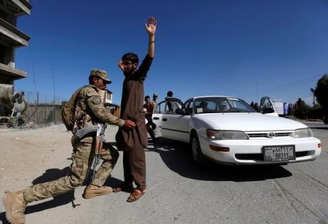 An Afghan policeman inspects passengers at a checkpoint on the outskirts of Jalalabad province, Afghanistan, April 29, 2016. PHOTO BY REUTERS/Parwiz