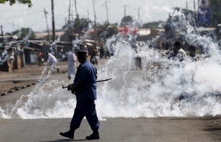 A policeman walks after throwing a teargas canister during a protest against Burundi President Pierre Nkurunziza and his bid for a third term in Bujumbura, Burundi, June 2, 2015. PHOTO BY REUTERS/Goran Tomasevic