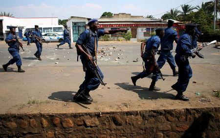 Policemen run towards protesters during a protest against President Pierre Nkurunziza's decision to run for a third term in Bujumbura, Burundi, May 29, 2015. PHOTO BY REUTERS/Goran Tomasevic