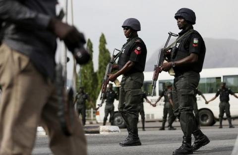 Police officers patrol near a journalist during a protest in Abuja, May 22, 2014. PHOTO BY REUTERS/Afolabi Sotunde