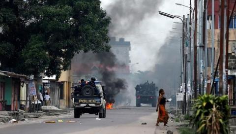 Congolese policemen drive past a fire barricade during demonstrations in the streets of the Democratic Republic of Congo's capital Kinshasa, December 20, 2016. PHOTO BY REUTERS/Thomas Mukoya