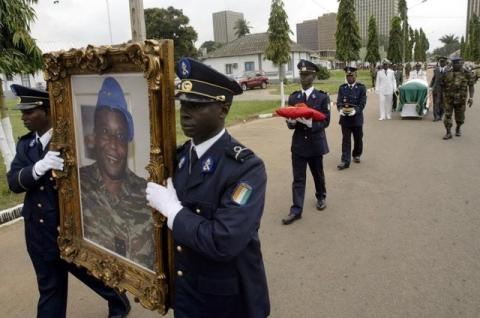 Ivory Coast soldiers carry the portrait and coffin of Robert Guei, former president and army general, during a funeral procession held at the Ivorian Army Chief of Staff headquarters in Abidjan in a file photo. PHOTO BY REUTERS/Thierry Gouegnon