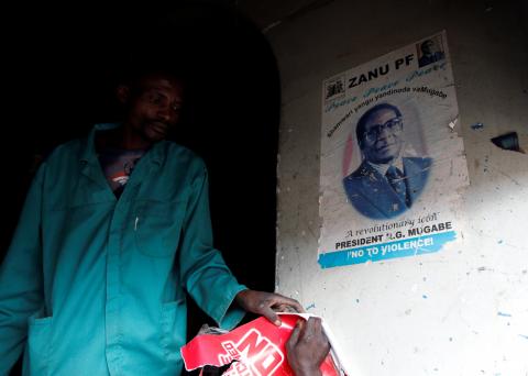 A man walks past a portrait of late former Zimbabwe's President Robert Mugabe, at a groceries store in Mbare township, Harare, Zimbabwe, September 7,2019. PHOTO BY REUTERS/Philimon Bulawayo