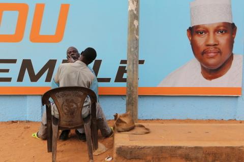 A man gets a haircut and a shave in front of a campaign poster of incarcerated opposition candidate Hama Amadou in Niamey, Niger, February 15, 2016. PHOTO BY REUTERS/Joe Penney