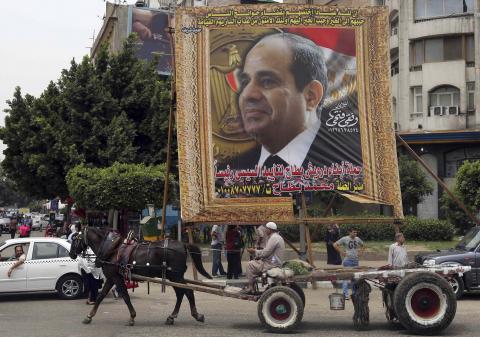 An Egyptian man on horse cart rides past a huge banner for Egypt's former army chief Field Marshal Abdel Fattah al-Sisi in downtown Cairo