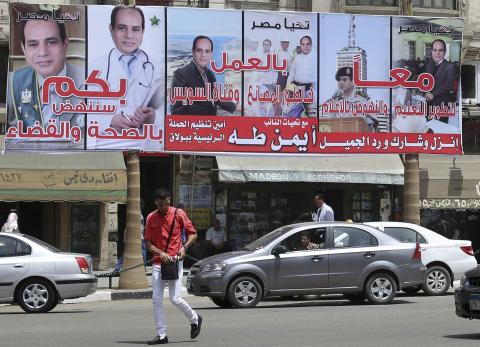 Vehicles are stuck in a traffic jam near an election campaign billboard of presidential candidate and former army chief Abdel Fattah al-Sisi on a building near Tahrir Square in Cairo