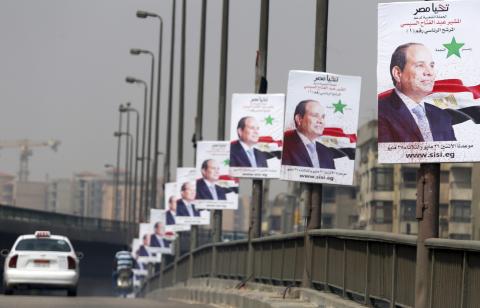 A car travels past posters of presidential candidate and Egypt's former army chief and Abdel Fattah al-Sisi on a bridge in Cairo