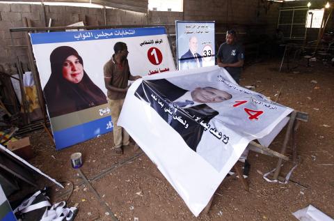 Workers prepare election campaign posters for Libya's House of Representatives in Tripoli