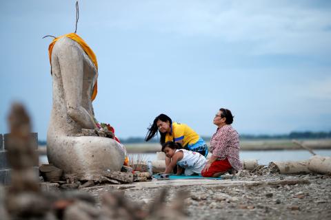 A family prays near the ruins of a headless Buddha statue, which has resurfaced in a dried-up dam due to drought, in Lopburi, Thailand, August 1, 2019. PHOTO BY REUTERS/Soe Zeya Tun