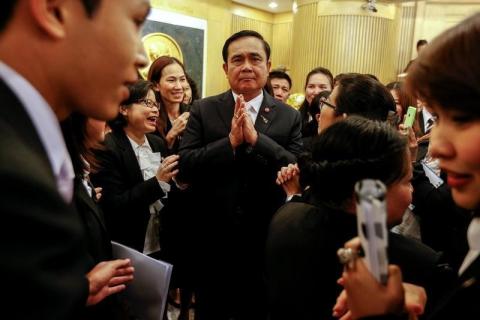 Thailand's Prime Minister Prayuth Chan-ocha (C) gestures in a traditional greeting after a speech at the Stock Exchange of Thailand in Bangkok, February 26, 2015. PHOTO BY REUTERS/Athit Perawongmetha