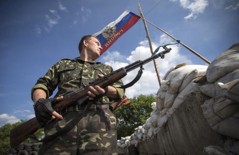 A pro-Russian separatist guards a road checkpoint outside the town of Lysychansk in the Luhansk region of eastern Ukraine