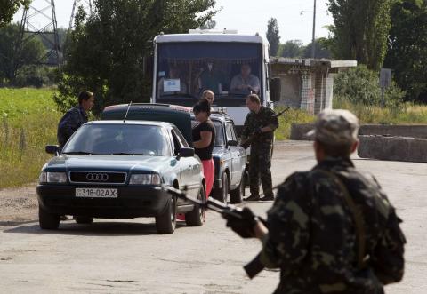 Pro-Russian separatists inspect vehicles at a road checkpoint outside the town of Lysychansk in the Luhansk region of eastern Ukraine