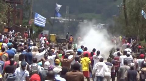 A still image taken from a video shot on October 1, 2017, shows protesters waving Ambazonian flags as they move forward towards barricades and police amid tear gas in the English-speaking city of Bamenda, Cameroon. PHOTO BY REUTERS