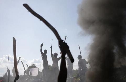 Men gesture in front of a burnt barricade during a protest against French soldiers in Bambari, May 22, 2014. PHOTO BY REUTERS/Goran Tomasevic