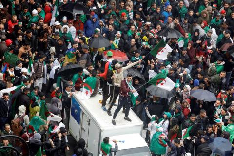 Demonstrators stand atop of a vehicle as they wave national flags during a protest calling on President Abdelaziz Bouteflika to quit, in Algiers, Algeria, March 22, 2019. PHOTO BY REUTERS/Zohra Bensemra