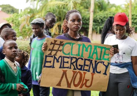 'Fridays for Future' coordinator Hilda Flavia Nakabuye holds a sign during the global 'School Strike for Climate' in Kampala, Uganda on May 24, 2019. PHOTO BY Thomson Reuters Foundation/Alice McCool