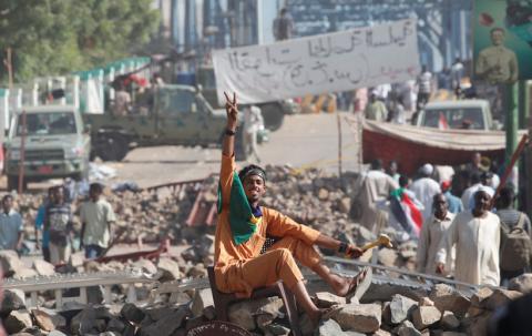 A Sudanese protester makes victory sign as he sits on a barricade on a road leading to the defense ministry compound in Khartoum, Sudan, April 30, 2019. PHOTO BY REUTERS/Umit Bektas