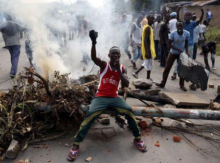 A protester sits in front of a burned barricade during a protest against Burundi President Pierre Nkurunziza and his bid for a third term in Bujumbura, Burundi, May 21, 2015. PHOTO BY REUTERS/Goran Tomasevic