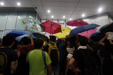 Protesters carry umbrellas to try to protect themselves from being pepper-sprayed during a confrontation with the police after a rally ahead of the October 1 "Occupy Central" civil disobedience movement in Hong Kong