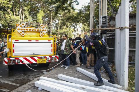 Anti-government protesters use a truck to tear down the fences of the Thai-Japan youth stadium during clashes in central Bangkok