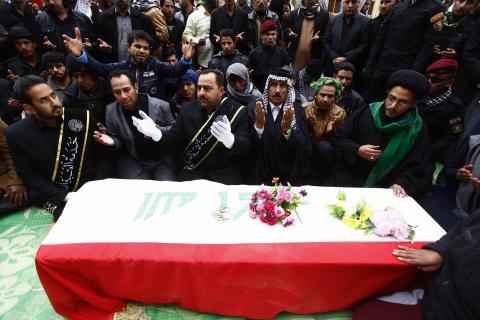 Mourners pray near the coffin of a soldier, who was killed during the clashes in Ramadi during the funeral in Najaf, 160 km (99 miles) south of Baghdad