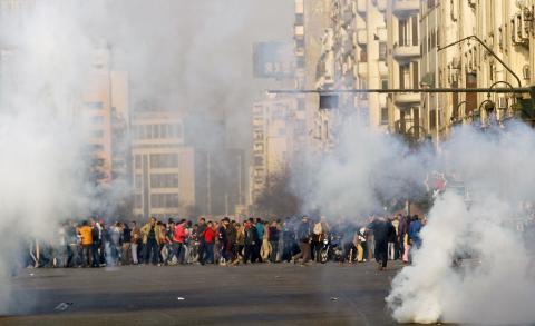 Anti-government protesters and members of the Muslim Brotherhood flee after teargas were fired by riot police during clashes at Ramsis street, which leads to Tahrir Square in downtown Cairo, on the third anniversary of Egypt's uprising