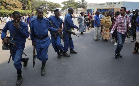 A protestor (R) jeers at policemen during Presidential election day in Bujumbura's Niyakabiga district, Burundi, July 21, 2015. PHOTO BY REUTERS/Mike Hutchings