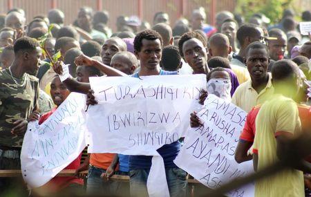 Protesters hold placards as they demonstrate against the ruling CNDD-FDD party's decision to allow Burundi President Pierre Nkurunziza to run for a third five-year term in office, in Bujumbura, May 4, 2015. PHOTO BY REUTERS/Jean Pierre Aime Harerimana