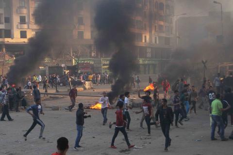 Protesters run during clashes with police in Ain Shams area east of Cairo