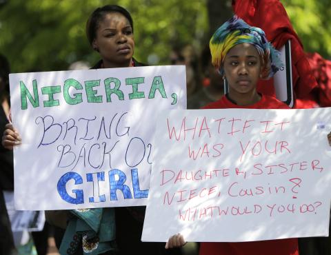 Protesters hold signs during a march in support of the girls kidnapped by members of Boko Haram in front of the Nigerian Embassy in Washington