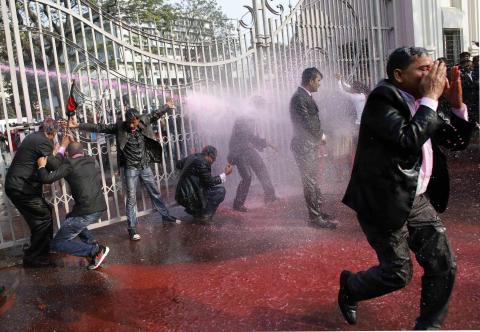 Lawyers loyal to Bangladesh Nationalist Party (BNP) and Bangladesh Jamaat-E-Islami shout slogans as policemen use water cannons during a protest inside the premises of Supreme Court in Dhaka