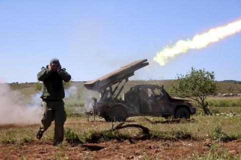 A rebel fighter from the Ahrar al-Sham Islamic Movement reacts as they fire grad rockets from Idlib countryside, towards forces loyal to Syria's President Bashar al-Assad stationed at Jureen town in al-Ghab plain in the Hama countryside, April 25, 2015. PHOTO BY REUTERS/Mohamad Bayoush