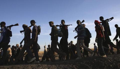 Rebel fighters walk in a rebel controlled territory in Upper Nile State