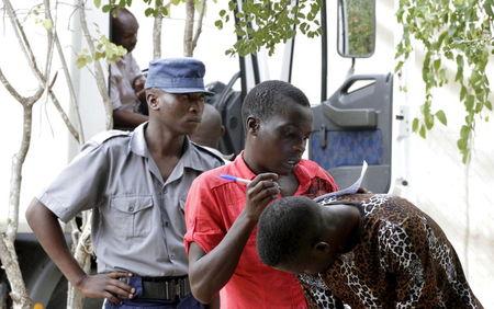 Refugees fleeing anti-immigrant violence fill in forms at a transit camp in Beit Bridge April 24, 2015. PHOTO BY REUTERS/Philimon Bulawayo